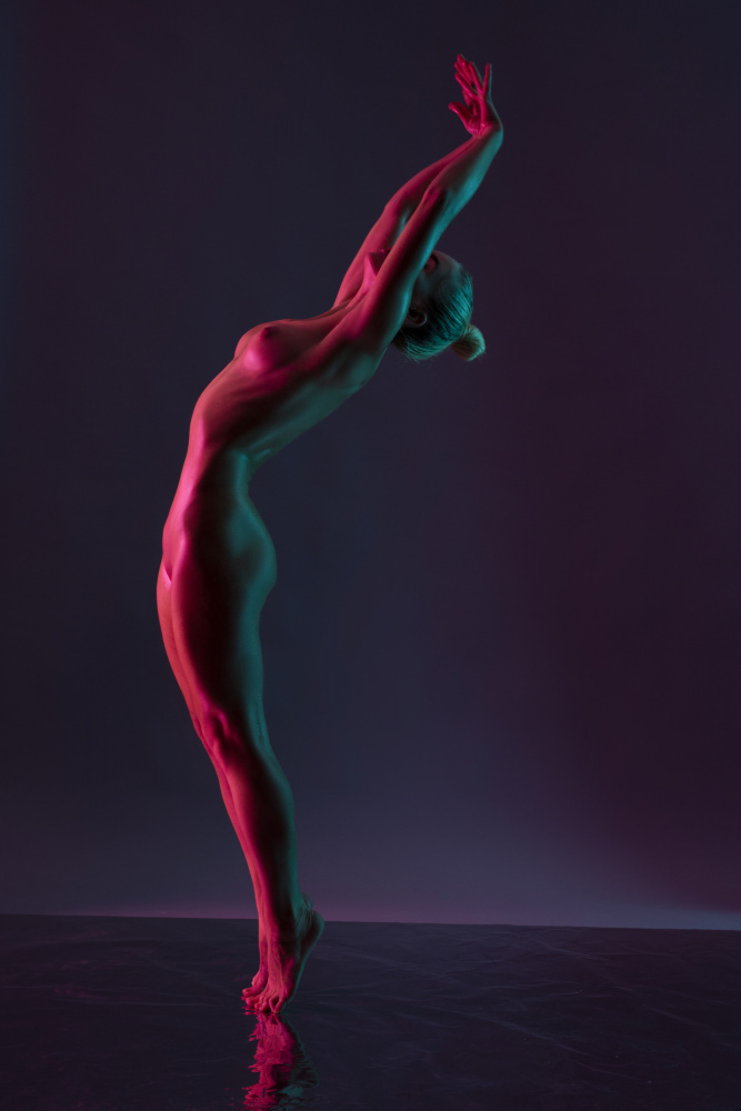 Young naked woman dance against dark purple background de Andrey Guryanov
