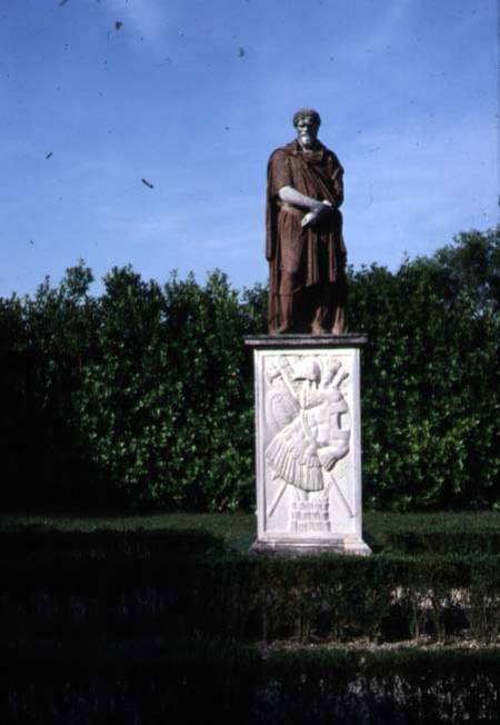 View of the garden detail of travertine sculpture of a male figure on a marble base decorated with a de Anonymous