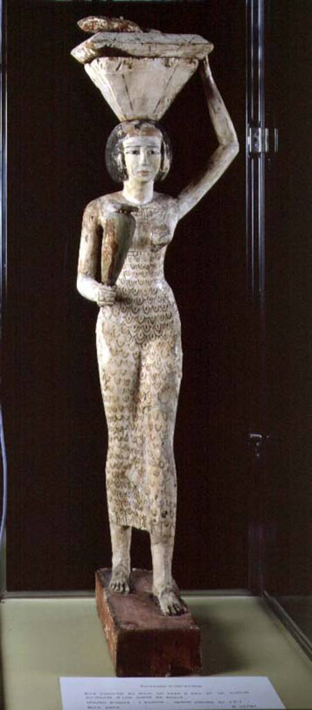 Female bearer of offerings carrying a water vase in her hand and a vessel on her head de Egyptian