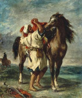 Un árabe ensilla su caballo