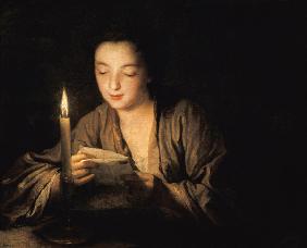 Una joven leyendo una carta bajo la luz de vela