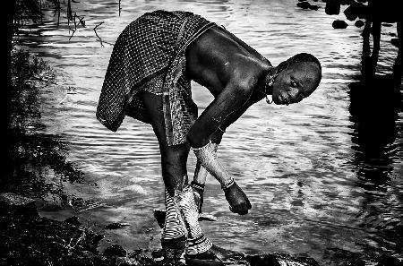 Surma tribe woman washing up her jewelry - Ethiopia