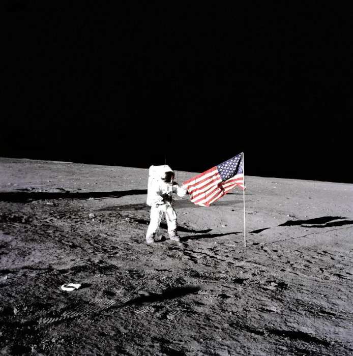 Apollo 12 Astronaut Charles Pete Conrad stands beside the United States flag after is was unfurled o de 