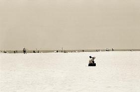 Man sitting on a beach playing his horn, 2004 (b/w photo) 